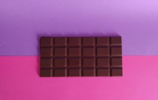 Image tablette de chocolat artisanale sur fond violet rose